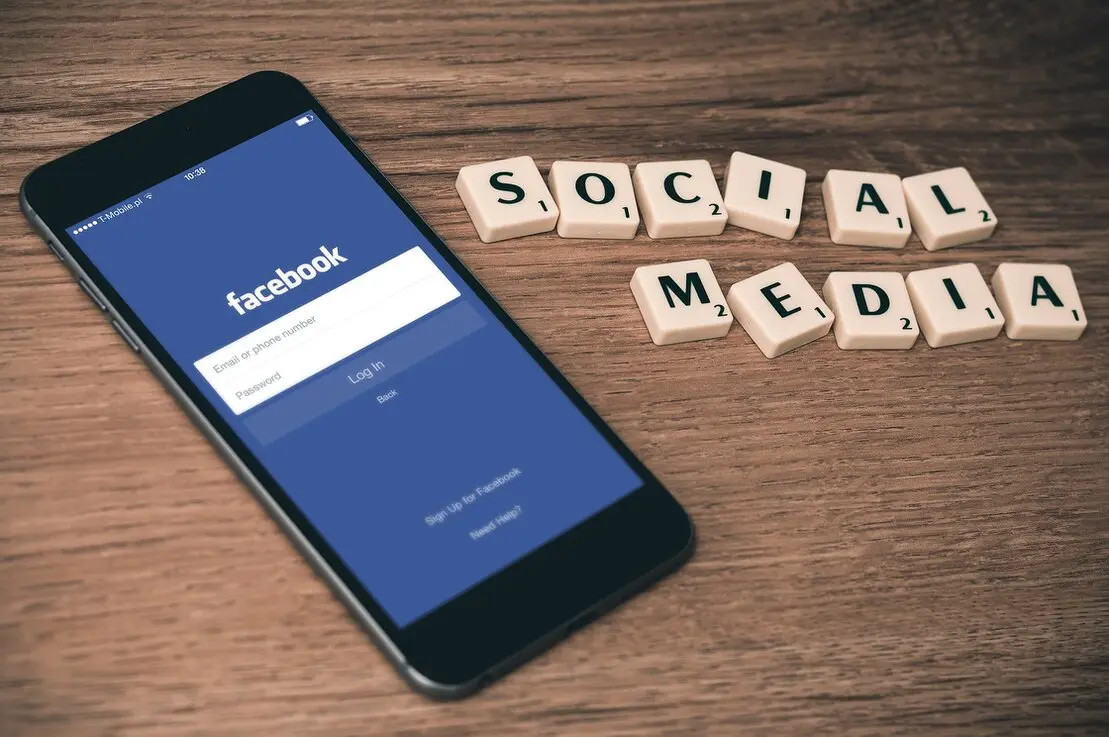 Osoba zarządzająca social mediami na smartfonie